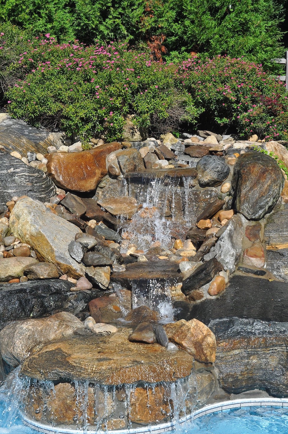 Custom water feature integrated into a finished outdoor landscape project